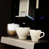 Szklanka kawy mlecznej i dwie filiżanki na tacy Coffee Format DOUBLE