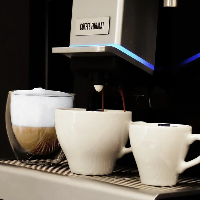 Coffee Format DOUBLE — kawa w szklance oraz dwie filiżanki przy wylewce